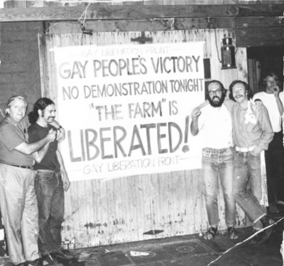 Black and white photo of 5 men flanking a sign saying "Gay People's Victory No Demonstration Tonight 'The Farm' is Liberated!"