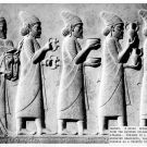 Photograph of the Apadana at the Palace of Persepolis that depicts five Syrians in a procession bringing bracelets, vases and vessels as a tribute to the king